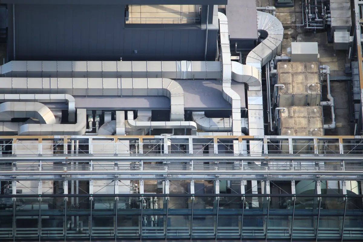 Equipos y ductos de climatización en una azotea; fotografía de referencia en Tokio.
